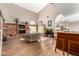 Open living room with brick fireplace, high ceilings, and bar area with wood floors at 908 N Creston --, Mesa, AZ 85213