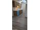Kitchen boasts wood-look floors, bright cabinets, and contrasting blue dishwasher at 10039 W Lancaster Dr, Sun City, AZ 85351