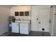 Bright laundry room with washer, dryer, water heater, and storage at 10039 W Lancaster Dr, Sun City, AZ 85351