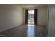 Spacious living room with wood-look floors, large window, and neutral paint at 10039 W Lancaster Dr, Sun City, AZ 85351