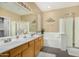Bright bathroom with double sinks, tile flooring, soaking tub, and separate glass shower at 10583 S 175Th Ave, Goodyear, AZ 85338