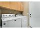 Laundry room with white appliances and wooden cabinets at 10583 S 175Th Ave, Goodyear, AZ 85338