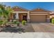 Well-maintained house showcasing a neat yard, brick driveway, and inviting covered porch with stone pillars at 12143 W Marguerite Ave, Avondale, AZ 85323
