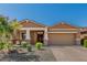 Beautiful home featuring a manicured lawn, brick driveway, and covered porch with stone accents at 12143 W Marguerite Ave, Avondale, AZ 85323