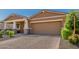 View of house with two-car garage, brick driveway, covered porch and desert landscaping at 12143 W Marguerite Ave, Avondale, AZ 85323