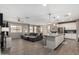 Open living space featuring tile floors, gray sectional sofa, and modern kitchen island at 12143 W Marguerite Ave, Avondale, AZ 85323