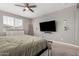 Comfortable main bedroom featuring a ceiling fan, dresser, and a large window at 12143 W Marguerite Ave, Avondale, AZ 85323