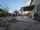 Backyard oasis showcasing a stone fire pit, BBQ, pool, covered patio, and mature palm trees at 12237 W Sherman St, Avondale, AZ 85323