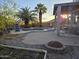 Backyard with mature palms, gravel, a stone fire pit, a pool, and a covered patio for outdoor entertaining at 12237 W Sherman St, Avondale, AZ 85323