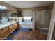Bright bathroom featuring a large soaking tub and separate glass-enclosed shower at 12237 W Sherman St, Avondale, AZ 85323