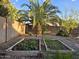 Backyard garden beds with brick and wood borders are surrounded by desert landscape with rock at 12237 W Sherman St, Avondale, AZ 85323