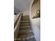 Carpeted staircase leading to the upper level, enhanced by a decorative niche and soft, neutral tones at 12237 W Sherman St, Avondale, AZ 85323