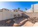 Landscaped backyard with stone patio and outdoor seating, creating a cozy and inviting retreat at 1226 E Presidio Rd, Phoenix, AZ 85022