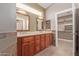 Bathroom featuring double sinks, wood cabinets and a walk in closet at 1226 E Presidio Rd, Phoenix, AZ 85022