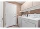 Laundry room featuring storage cabinets, washer, and dryer at 1226 E Presidio Rd, Phoenix, AZ 85022