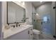 Modern bathroom featuring quartz counters, a large mirror, and a glass-enclosed shower at 1250 E Smokehouse Trl, Phoenix, AZ 85085