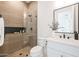 Modern bathroom with a walk-in shower featuring stylish wood-look tile, a black faucet, and a white vanity at 1250 E Smokehouse Trl, Phoenix, AZ 85085