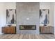Close-up of a contemporary fireplace with stone surround flanked by artistic accents and wood cabinets at 1250 E Smokehouse Trl, Phoenix, AZ 85085