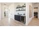 Chic hallway bar featuring dark cabinets, wine fridge, display shelving, and stylish decor at 1250 E Smokehouse Trl, Phoenix, AZ 85085