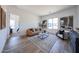 Spacious living room showcasing wood-look tile floors, neutral tones, and modern furnishings with large windows at 1250 E Smokehouse Trl, Phoenix, AZ 85085