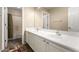 Bathroom featuring a dual sink vanity with white cabinets and chrome fixtures and a walk-in shower at 13313 W Palo Verde Dr, Litchfield Park, AZ 85340