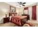 Bedroom featuring a ceiling fan, a queen-sized bed and a dresser with a mirror at 13313 W Palo Verde Dr, Litchfield Park, AZ 85340