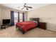 Bedroom featuring a ceiling fan, and large window with blinds and a red bedspread at 13313 W Palo Verde Dr, Litchfield Park, AZ 85340