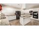 Modern kitchen with white cabinets, stainless steel appliances, granite countertops, and central island at 13313 W Palo Verde Dr, Litchfield Park, AZ 85340