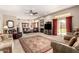 Open living room featuring a ceiling fan, fireplace, and large windows that provide ample natural light at 13313 W Palo Verde Dr, Litchfield Park, AZ 85340