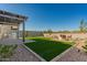This backyard has a built-in grill, artificial grass, and outdoor seating area perfect for entertaining and relaxation at 13618 W Phacelia Ln, Peoria, AZ 85383