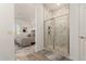 Bathroom featuring a stand-up shower with marble design, and a view to the bedroom at 13618 W Phacelia Ln, Peoria, AZ 85383