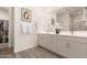 Bright bathroom featuring double sinks, a large mirror and a walk-in closet at 13618 W Phacelia Ln, Peoria, AZ 85383