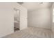 Spacious bedroom with neutral carpet and view to the bathroom at 13618 W Phacelia Ln, Peoria, AZ 85383
