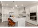 Modern kitchen boasts stainless steel appliances, a large island with seating, and white cabinetry at 13618 W Phacelia Ln, Peoria, AZ 85383