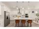 Bright kitchen featuring an island with seating, sleek appliances, and ample counter space at 13618 W Phacelia Ln, Peoria, AZ 85383