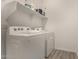 Well-organized laundry room featuring a modern washer and dryer with convenient overhead shelving at 13618 W Phacelia Ln, Peoria, AZ 85383