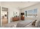 Bedroom with a large window, dresser, TV, and view into the hall and kitchen at 13618 W Phacelia Ln, Peoria, AZ 85383