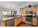 Bright kitchen with stainless appliances, center island with granite countertops, and wood cabinets at 1474 E Riviera Dr, Chandler, AZ 85249