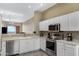 Bright kitchen with white cabinets, stainless steel appliances and view into the living room at 15025 E Scarlet Sky Ln # 1, Fountain Hills, AZ 85268