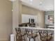 A view of the kitchen with a bar and three stools with a stainless steel microwave and oven at 15025 E Scarlet Sky Ln # 1, Fountain Hills, AZ 85268