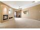 Spacious living room features a fireplace, a ceiling fan, view to the patio and neutral colors at 15025 E Scarlet Sky Ln # 1, Fountain Hills, AZ 85268