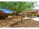 Private backyard oasis featuring desert landscaping, mature trees, and relaxing seating at 17139 S 174Th Dr, Goodyear, AZ 85338