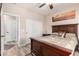 Cozy bedroom features a wood-framed bed, ceiling fan, and ensuite bathroom access at 17139 S 174Th Dr, Goodyear, AZ 85338
