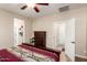 Comfortable bedroom featuring wood-style flooring, a ceiling fan, and access to an ensuite bathroom at 17139 S 174Th Dr, Goodyear, AZ 85338