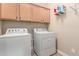A fully equipped laundry room features a washer, dryer, and cabinetry for ample storage space at 17139 S 174Th Dr, Goodyear, AZ 85338