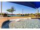 Gathering-friendly splash pad and community pool with chairs, shading, and a pristine lake backdrop at 17139 S 174Th Dr, Goodyear, AZ 85338