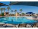Resort-style swimming pool with poolside chairs, umbrellas, palm trees, and shade structures at 17139 S 174Th Dr, Goodyear, AZ 85338