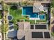 Aerial view of backyard with pool, spa, covered patio, trampoline, and solar panels on this luxury home at 17937 E Colt Ct, Queen Creek, AZ 85142