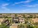 Expansive aerial view of a desert neighborhood featuring a luxury home with solar panels, pool, and green grass at 17937 E Colt Ct, Queen Creek, AZ 85142