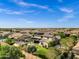 Aerial view of a desert neighborhood featuring a home with solar panels, pool, trampoline, and green landscaping at 17937 E Colt Ct, Queen Creek, AZ 85142